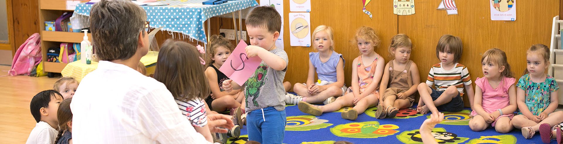 Teacher with a group of children on a carpet